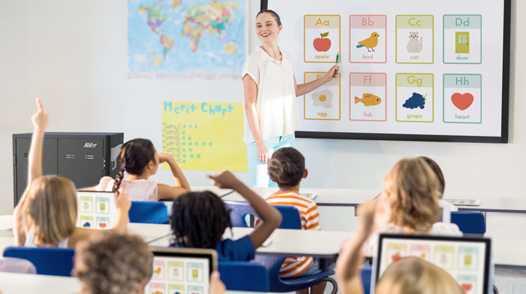 Students playing interactive learning games with tablets in classroom.