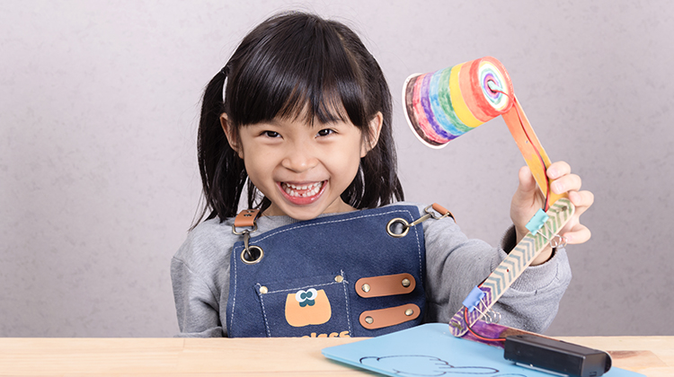 A child values her DIY craft because she made it herself, showcasing the IKEA Effect.