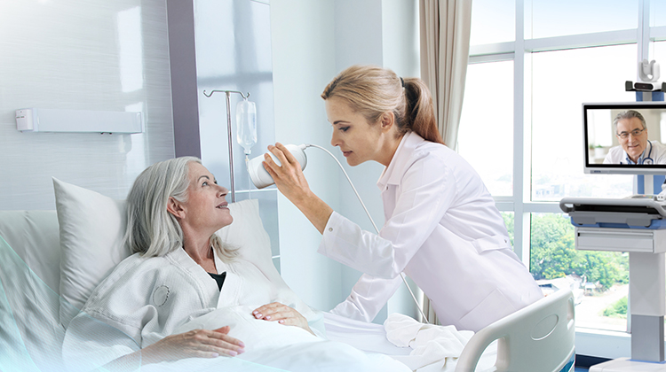 Healthcare professional using telehealth camera so that a remote doctor is able to so the patient.