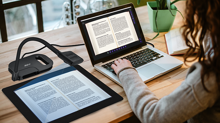 An AVer Vizualizer/doc cam capturing text from a document on a scanning mat, with a computer receiving the document in digital form.